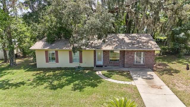 881 Cedar Cir, Tavares, FL 32778 - view of front facade featuring a front lawn, driveway, roof with shingles, and brick siding