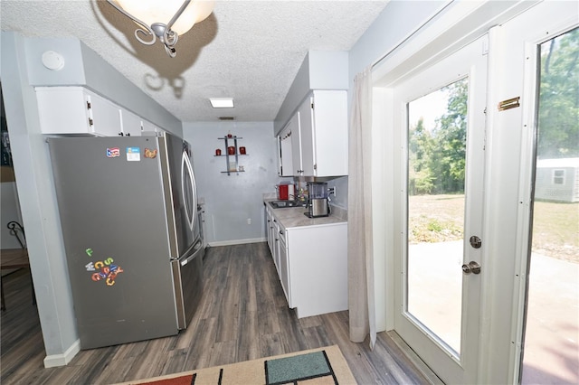 881 Cedar Cir, Tavares, FL 32778 - kitchen featuring freestanding refrigerator, dark wood-style floors, light countertops, white cabinets, and a textured ceiling