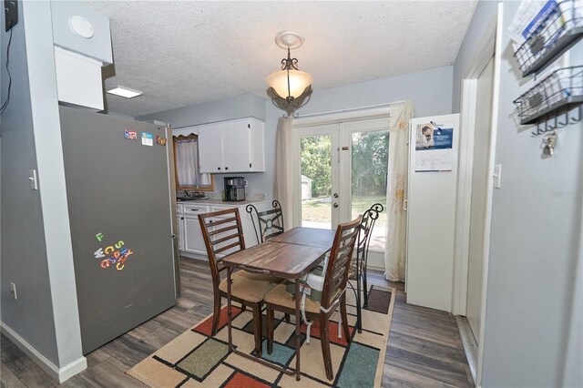 881 Cedar Cir, Tavares, FL 32778 - dining area with french doors, dark wood finished floors, a textured ceiling, and baseboards
