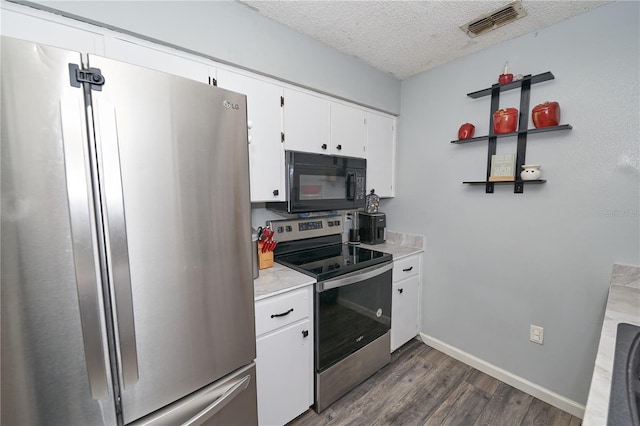 881 Cedar Cir, Tavares, FL 32778 - kitchen with appliances with stainless steel finishes, a textured ceiling, dark wood-type flooring, light countertops, and white cabinets