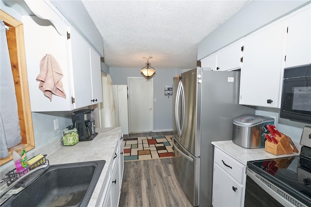 881 Cedar Cir, Tavares, FL 32778 - kitchen featuring stainless steel appliances, a sink, dark wood finished floors, white cabinetry, and a textured ceiling