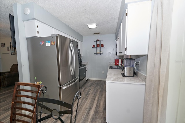 881 Cedar Cir, Tavares, FL 32778 - kitchen featuring appliances with stainless steel finishes, a textured ceiling, light countertops, white cabinetry, and dark wood-type flooring