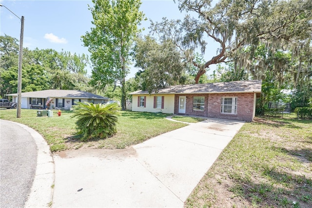 881 Cedar Cir, Tavares, FL 32778 - ranch-style house with driveway, brick siding, and a front lawn