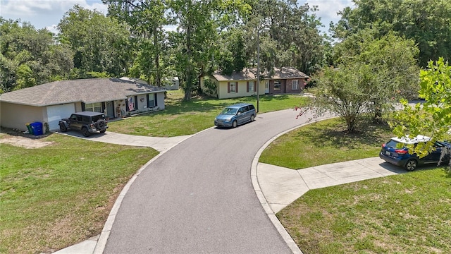 881 Cedar Cir, Tavares, FL 32778 - view of front of property featuring concrete driveway, a front yard, a garage, and view of wooded area