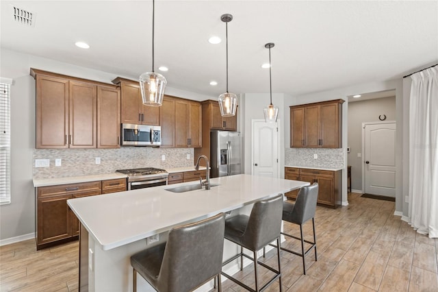 16013 Tollington Aly, Winter Garden, FL 34787 - kitchen featuring stainless steel appliances, a sink, brown cabinets, decorative backsplash, and recessed lighting