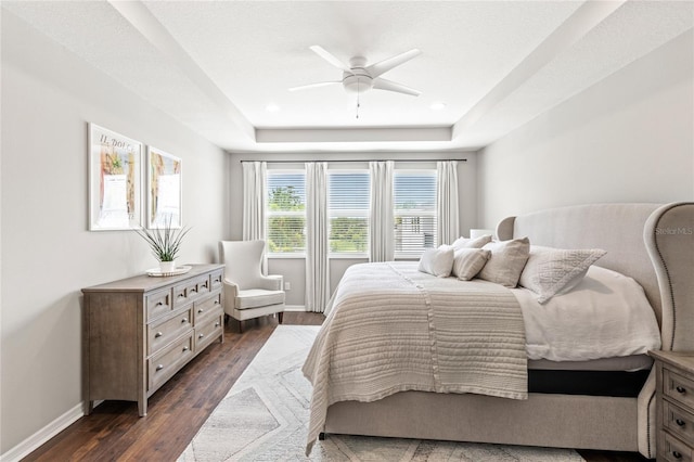 16013 Tollington Aly, Winter Garden, FL 34787 - bedroom featuring a tray ceiling, dark wood-style floors, baseboards, and ceiling fan