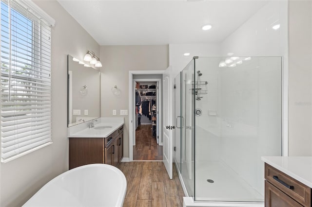 16013 Tollington Aly, Winter Garden, FL 34787 - full bath with vanity, a shower stall, a spacious closet, a soaking tub, and wood finished floors