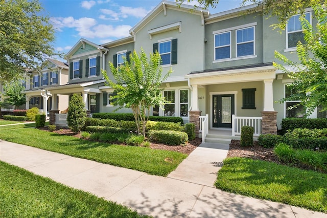 15477 Blackbead St, Winter Garden, FL 34787 - view of front of home featuring stucco siding, covered porch, and a front yard