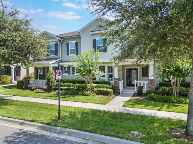 15477 Blackbead St, Winter Garden, FL 34787 - view of front facade with a porch, stucco siding, and a front yard