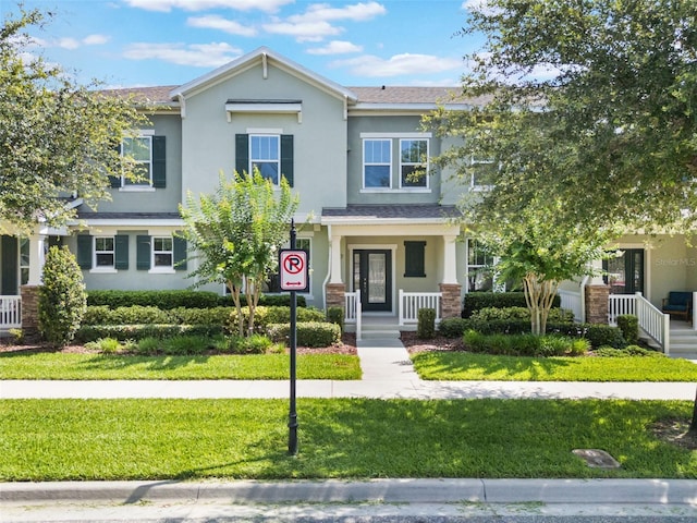 15477 Blackbead St, Winter Garden, FL 34787 - view of front of home featuring stucco siding, covered porch, and a front lawn