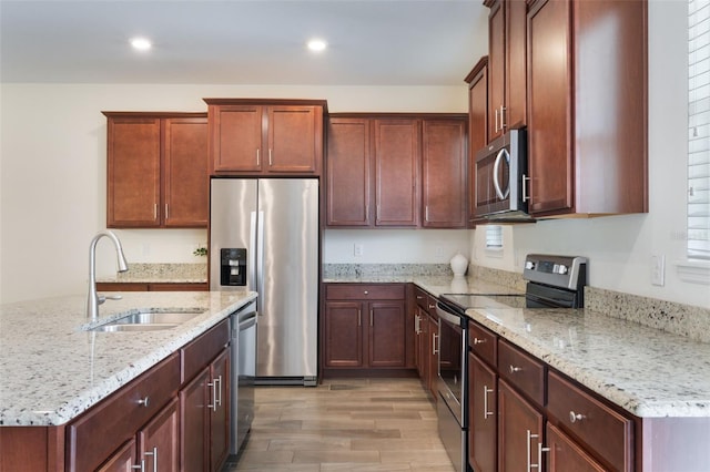 15477 Blackbead St, Winter Garden, FL 34787 - kitchen featuring appliances with stainless steel finishes, a sink, light wood finished floors, light stone countertops, and recessed lighting