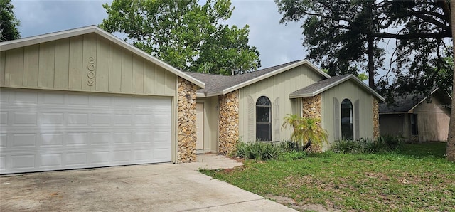 2008 Juniper Dr, Edgewater, FL 32141 - ranch-style house featuring stone siding, roof with shingles, a garage, and concrete driveway