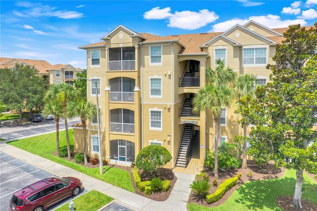 2821 Almaton Loop Unit 105, Kissimmee, FL 34747 - view of property with uncovered parking and stairway