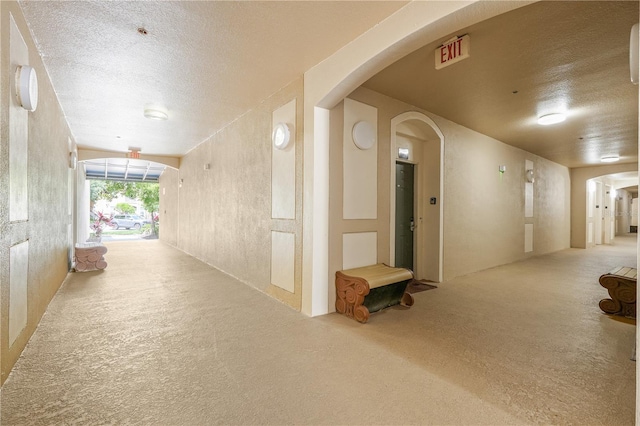 2821 Almaton Loop Unit 105, Kissimmee, FL 34747 - corridor with a textured ceiling, arched walkways, and carpet