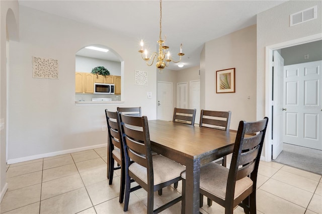 2821 Almaton Loop Unit 105, Kissimmee, FL 34747 - dining room with light tile patterned floors, a chandelier, arched walkways, and baseboards