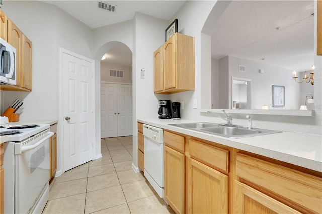 2821 Almaton Loop Unit 105, Kissimmee, FL 34747 - kitchen with white appliances, arched walkways, light brown cabinets, a sink, and light tile patterned flooring