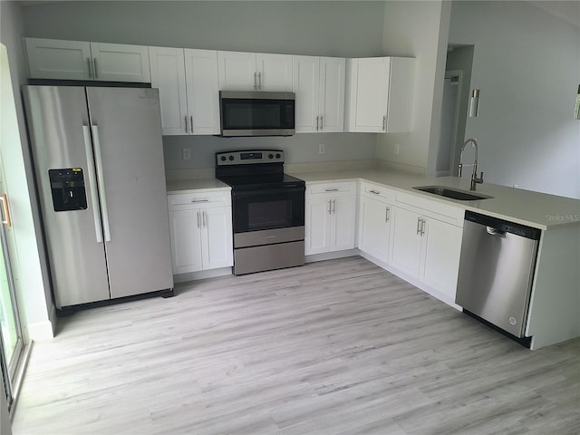 4333 SW 157th Ter, Ocala, FL 34481 - kitchen featuring stainless steel appliances, a sink, white cabinets, light wood-style floors, and light countertops