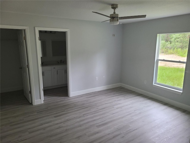 4333 SW 157th Ter, Ocala, FL 34481 - unfurnished bedroom with wood finished floors, baseboards, ensuite bath, a sink, and ceiling fan
