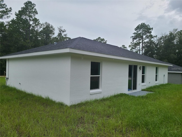 4333 SW 157th Ter, Ocala, FL 34481 - back of property with stucco siding, a yard, and roof with shingles