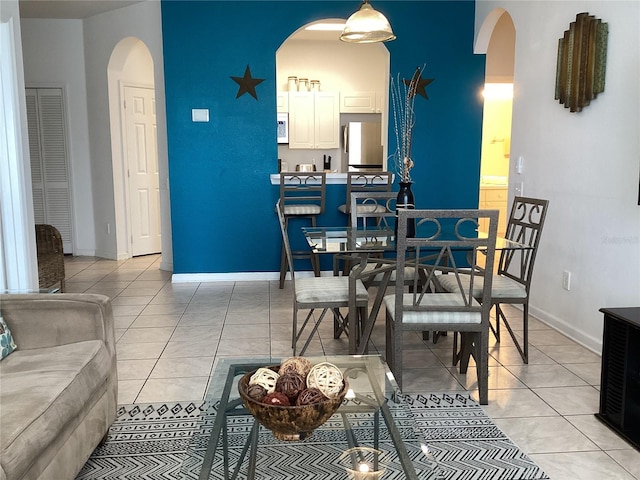 2305 Butterfly Palm Way Unit 304, Kissimmee, FL 34747 - dining space featuring arched walkways, light tile patterned floors, and baseboards