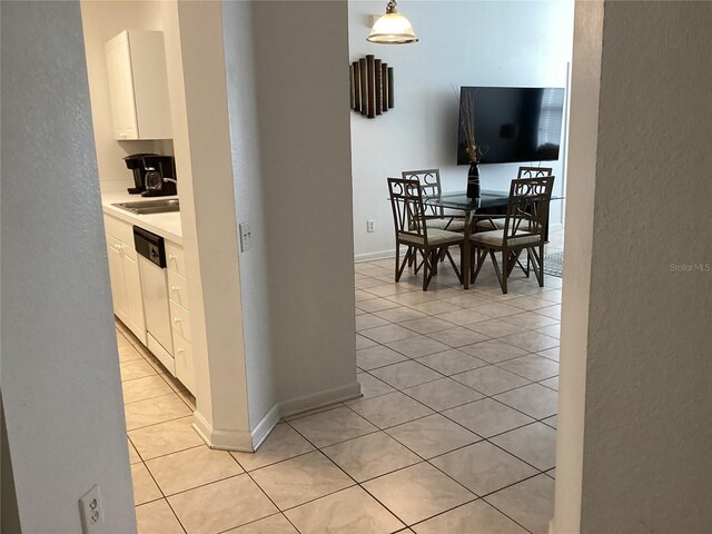 2305 Butterfly Palm Way Unit 304, Kissimmee, FL 34747 - kitchen with light tile patterned flooring, white cabinets, light countertops, dishwasher, and a textured wall