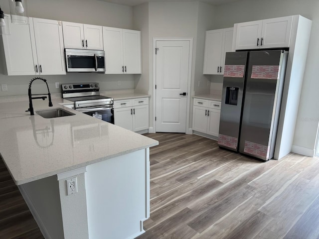 706 Marion Oaks Mnr, Ocala, FL 34473 - kitchen with stainless steel appliances, a peninsula, a sink, light stone counters, and light wood finished floors