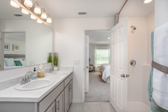 2352 W Newhope Ln, Citrus Springs, FL 34434 - ensuite bathroom featuring double vanity, tile patterned flooring, tiled shower, and baseboards