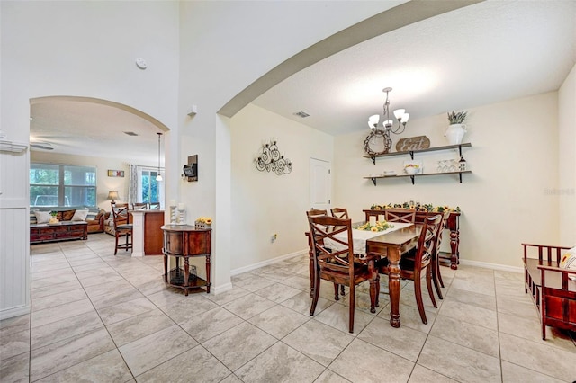 998 Sorrel St NW, Palm Bay, FL 32907 - dining area with arched walkways, a chandelier, light tile patterned floors, and baseboards