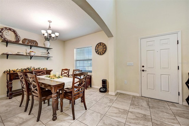 998 Sorrel St NW, Palm Bay, FL 32907 - dining area featuring arched walkways, a chandelier, a textured ceiling, baseboards, and light tile patterned floors