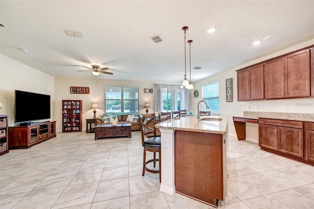 998 Sorrel St NW, Palm Bay, FL 32907 - kitchen with a textured ceiling, open floor plan, a sink, healthy amount of natural light, and a ceiling fan