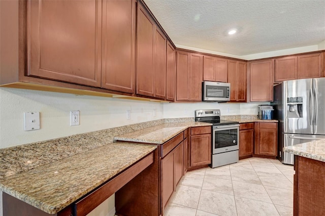 998 Sorrel St NW, Palm Bay, FL 32907 - kitchen with stainless steel appliances, brown cabinets, light stone countertops, a textured ceiling, and recessed lighting