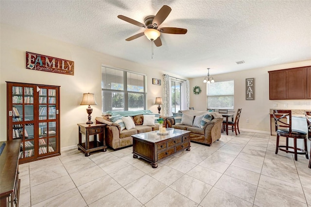 998 Sorrel St NW, Palm Bay, FL 32907 - living room with a ceiling fan, a textured ceiling, light tile patterned floors, a chandelier, and baseboards