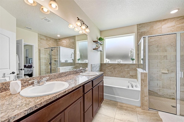 998 Sorrel St NW, Palm Bay, FL 32907 - bathroom with ensuite bath, a bath, a shower stall, a textured ceiling, and double vanity