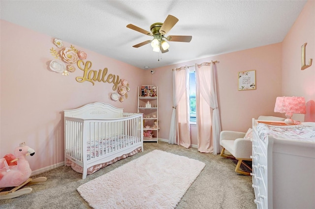 998 Sorrel St NW, Palm Bay, FL 32907 - bedroom with carpet floors, a nursery area, a textured ceiling, a ceiling fan, and baseboards