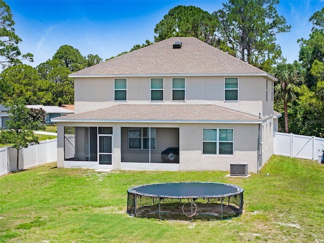 998 Sorrel St NW, Palm Bay, FL 32907 - back of property with a trampoline, roof with shingles, a sunroom, stucco siding, and a gate