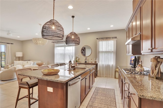1650 Key Bay Trl, Kissimmee, FL 34747 - kitchen featuring stainless steel appliances, under cabinet range hood, a sink, a breakfast bar, and light stone countertops