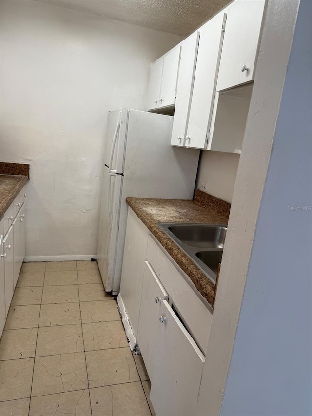 914 SW 8th Ave Unit 14, Gainesville, FL 32601 - kitchen with a sink, dark countertops, white cabinets, and baseboards