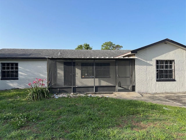2085 San Jose Blvd, Orlando, FL 32808 - back of property with a sunroom, brick siding, and a lawn