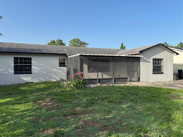 2085 San Jose Blvd, Orlando, FL 32808 - rear view of property featuring a sunroom, brick siding, and a yard