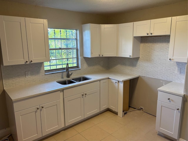 2085 San Jose Blvd, Orlando, FL 32808 - kitchen featuring a sink, decorative backsplash, white cabinetry, and light tile patterned floors