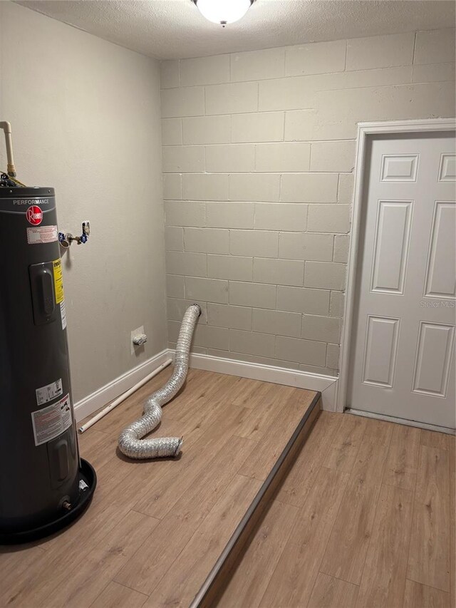 2085 San Jose Blvd, Orlando, FL 32808 - exercise room featuring water heater, wood finished floors, and concrete block wall