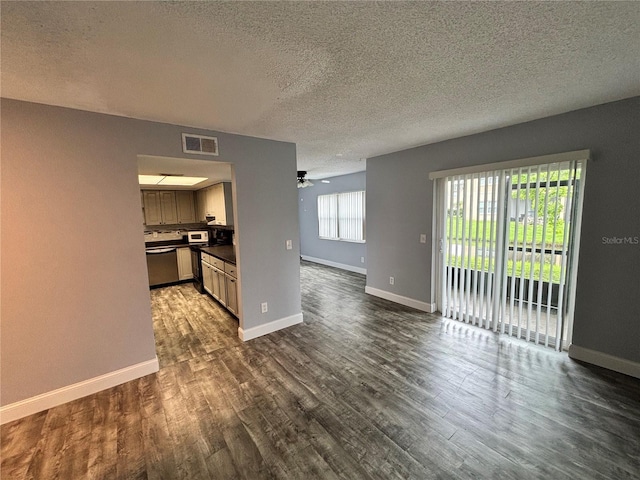 9918 Turf Way Unit 5, Orlando, FL 32837 - unfurnished living room featuring dark wood-type flooring, a textured ceiling, baseboards, and ceiling fan