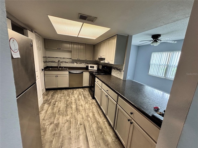 9918 Turf Way Unit 5, Orlando, FL 32837 - kitchen with stainless steel appliances, dark countertops, light wood-style floors, ceiling fan, and a sink