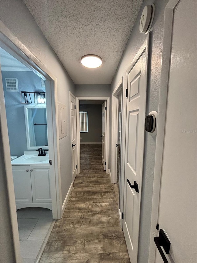 9918 Turf Way Unit 5, Orlando, FL 32837 - corridor with a sink, dark wood-type flooring, a textured ceiling, and baseboards