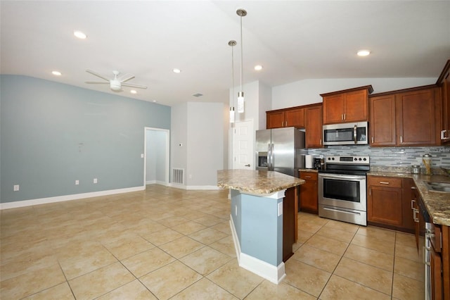 1061 Citrus Landings Blvd, Davenport, FL 33837 - kitchen with appliances with stainless steel finishes, vaulted ceiling, backsplash, light tile patterned floors, and a kitchen island