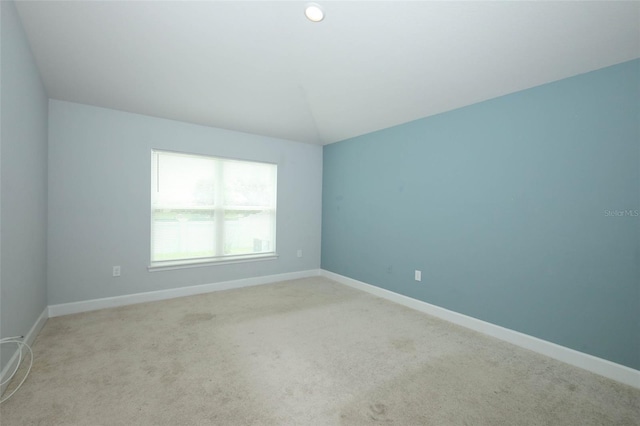 1061 Citrus Landings Blvd, Davenport, FL 33837 - empty room with light carpet, baseboards, and vaulted ceiling
