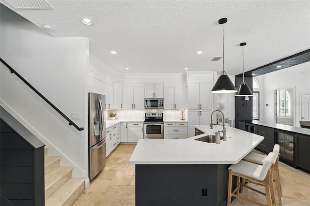 2908 Lee Shore Loop, Orlando, FL 32820 - kitchen featuring stainless steel appliances, a sink, wine cooler, white cabinetry, and recessed lighting