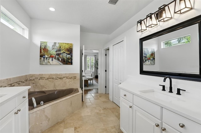 2908 Lee Shore Loop, Orlando, FL 32820 - bathroom with vanity, a bath, stone finish floors, and recessed lighting