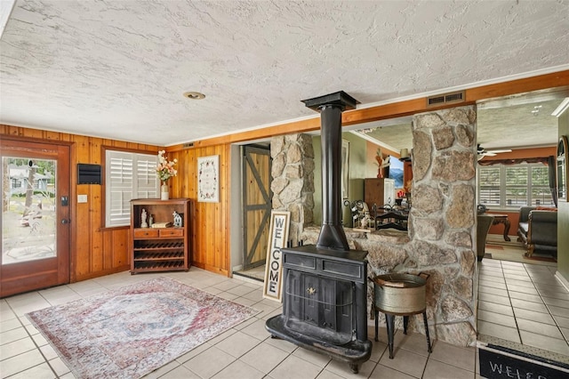 3312 SE 6th St, Ocala, FL 34471 - living room with tile patterned floors, a textured ceiling, a wood stove, and wooden walls