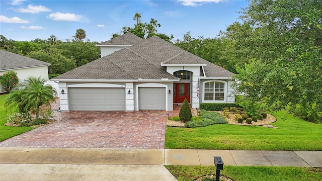 405 Courtlea Park Dr, Winter Garden, FL 34787 - view of front of home featuring stucco siding, an attached garage, a front lawn, and decorative driveway
